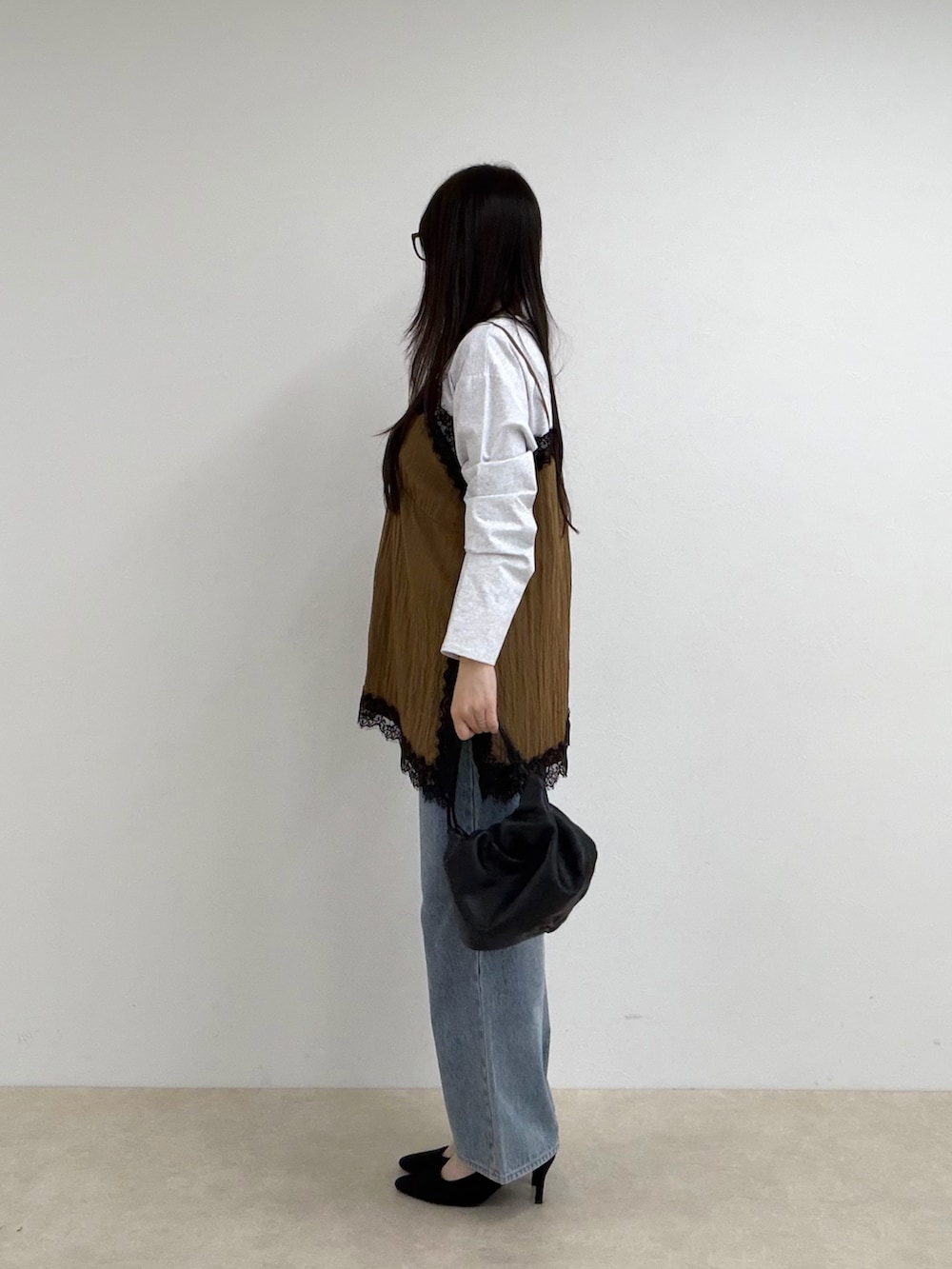 イエロー系のTシャツ/カットソー、ブルー系のデニムパンツを着用したレディースの秋コーディネートの2枚目の写真