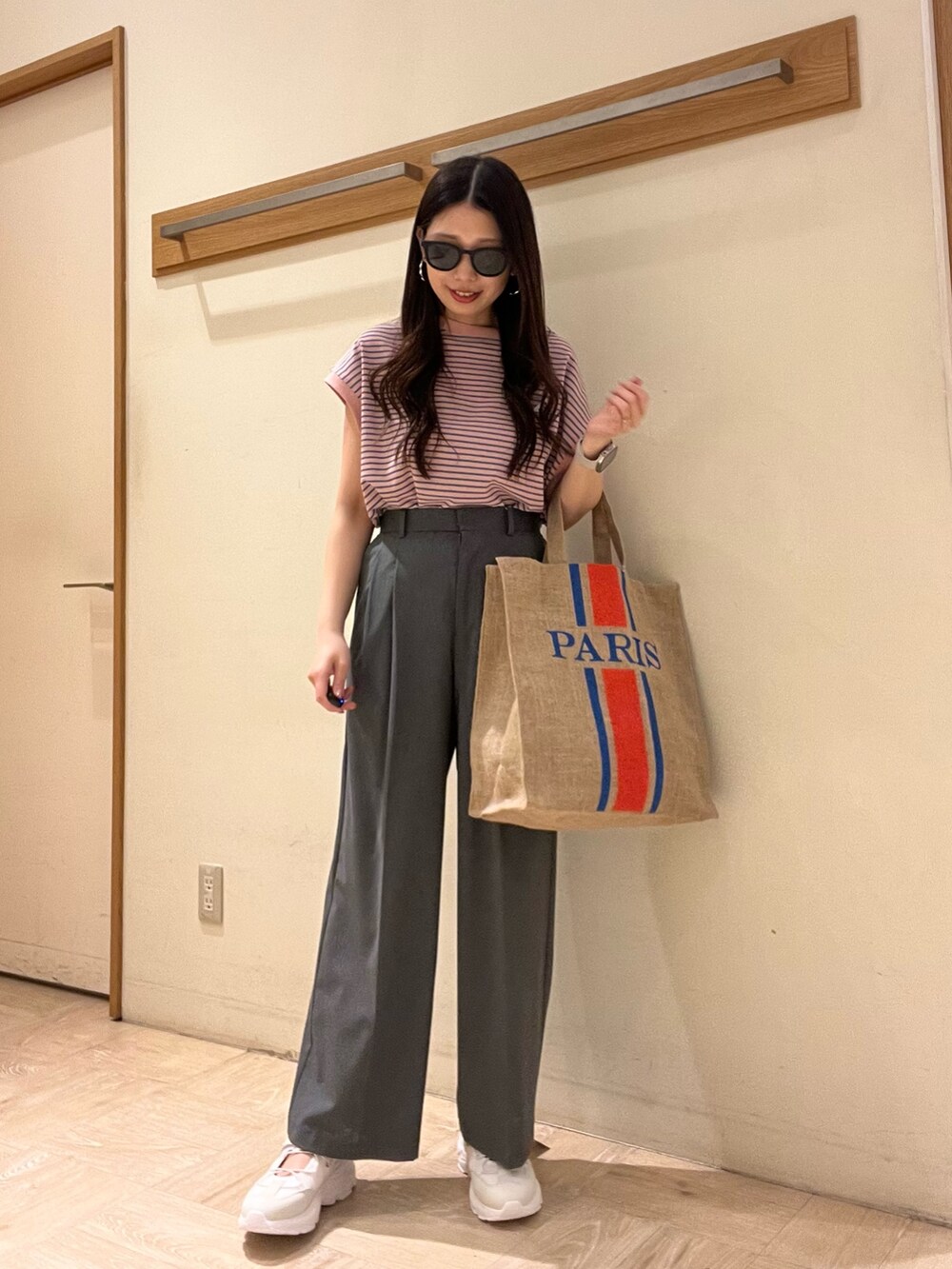ホワイト系のTシャツ/カットソー、グレー系のスラックス、ブラック系のトートバッグを着用したレディースの夏コーディネートの4枚目の写真