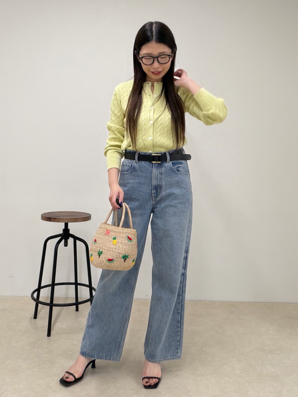 グリーン系のカーディガン/ボレロ、ブルー系のデニムパンツ、ベージュ系のかごバッグを着用したレディースの春コーディネートの2枚目の写真