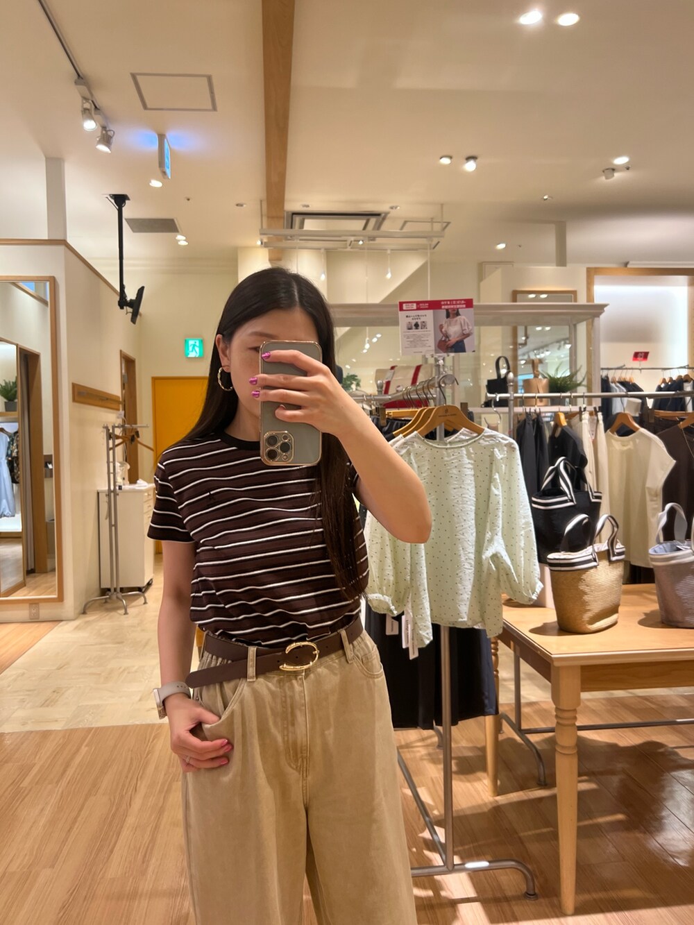 ベージュ系のTシャツ/カットソー、ベージュ系のデニムパンツ、ブラウン系のベルトを着用したレディースの夏コーディネートの4枚目の写真