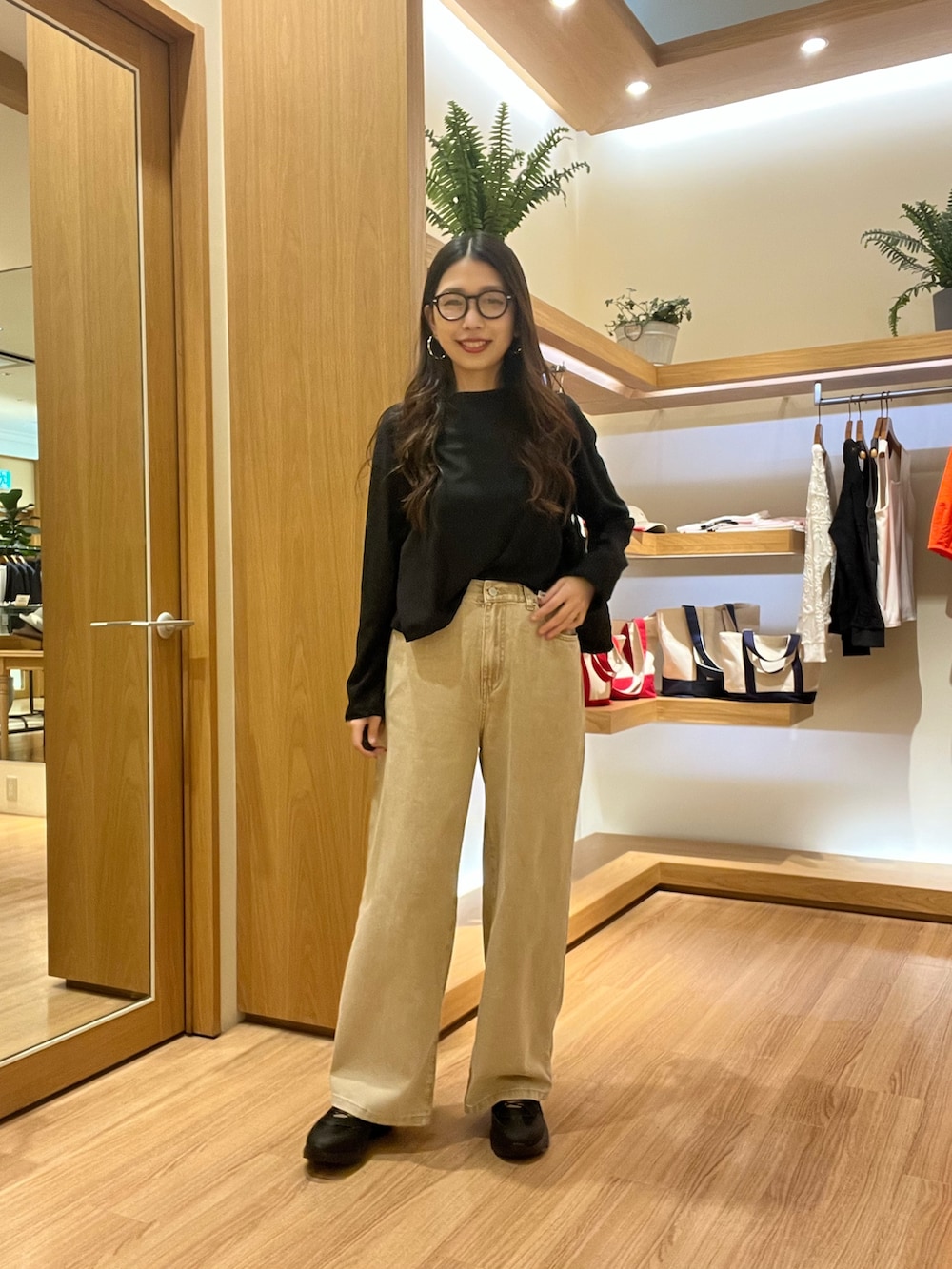 ブラック系のTシャツ/カットソー、ベージュ系のデニムパンツ、ブラック系のサングラスを着用したレディースの夏コーディネートの7枚目の写真