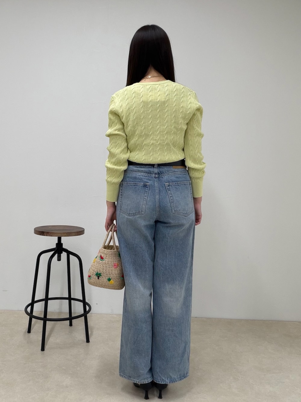 グリーン系のカーディガン/ボレロ、ブルー系のデニムパンツ、ベージュ系のかごバッグを着用したレディースの春コーディネートの4枚目の写真