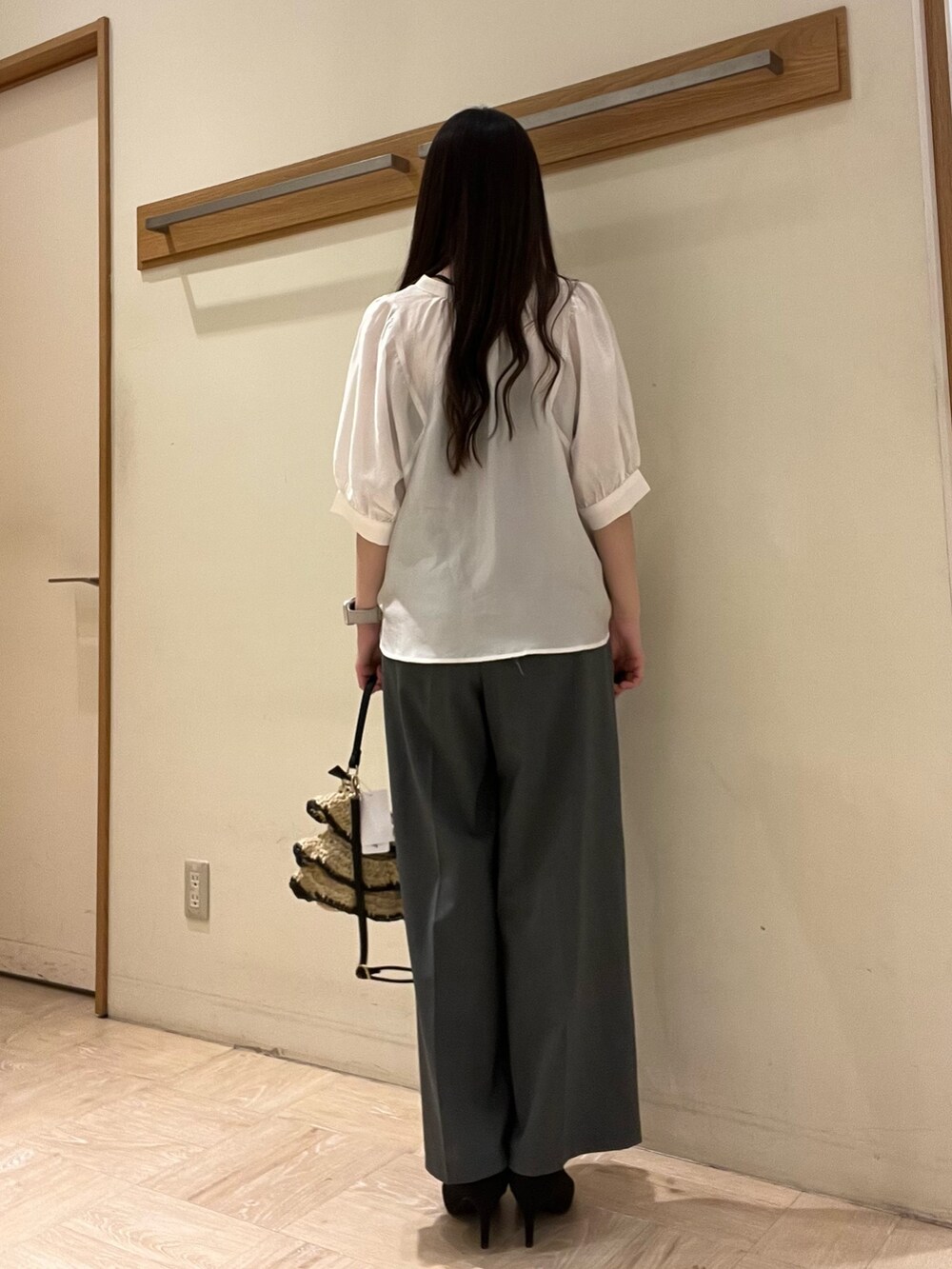 ホワイト系のシャツ/ブラウス、グレー系のスラックス、ブラック系のかごバッグを着用したレディースの夏コーディネートの5枚目の写真