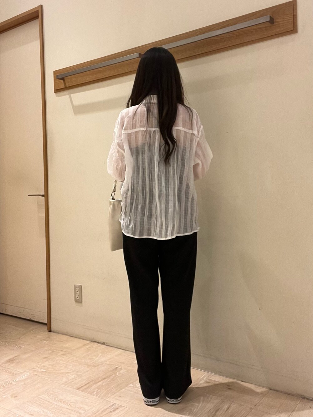 ホワイト系のショルダーバッグ、ブラック系のスラックス、ホワイト系のシャツ/ブラウスを着用したレディースの春コーディネートの3枚目の写真