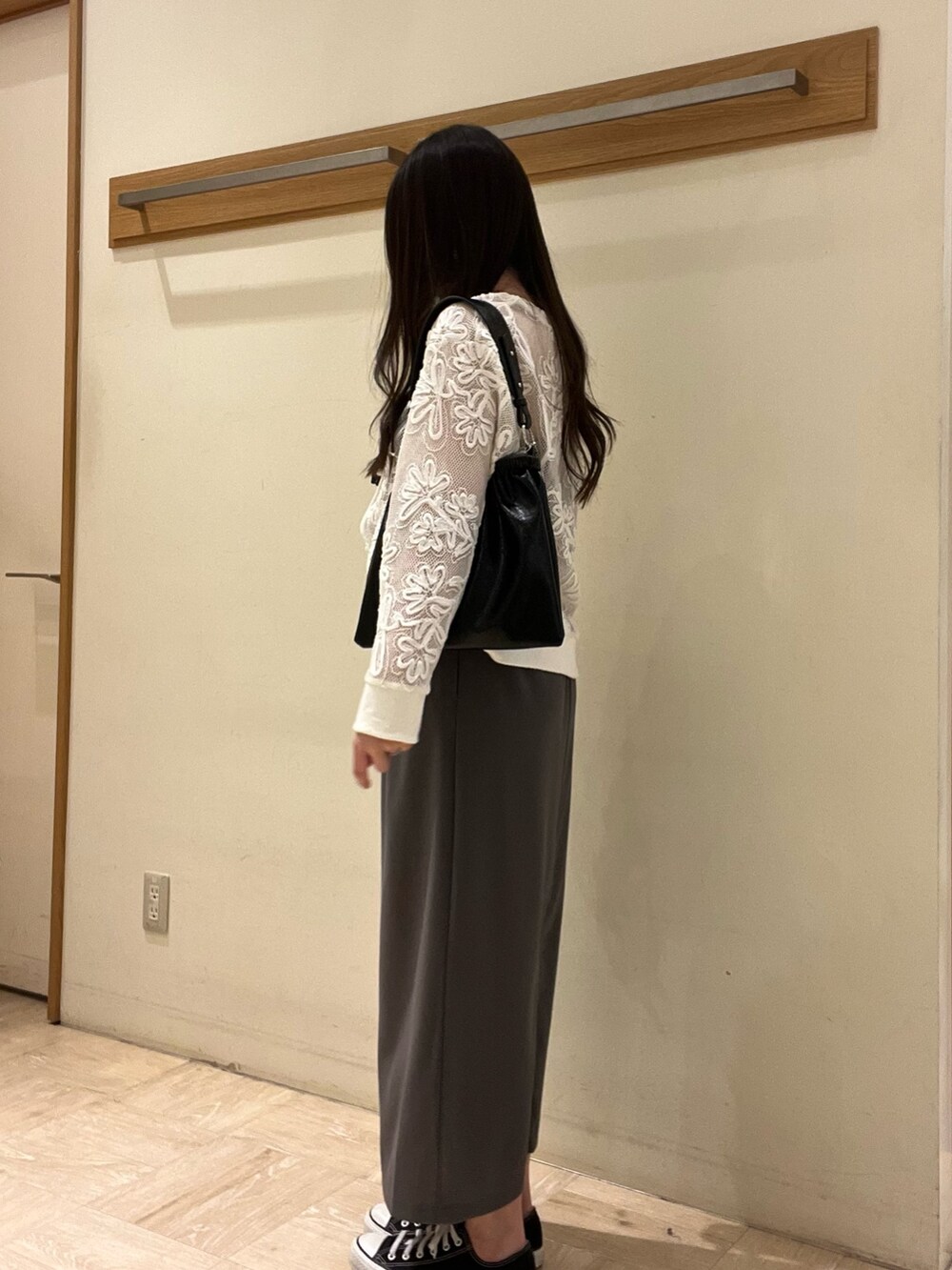 グレー系のスカート、ホワイト系のカーディガン/ボレロ、ブラック系のショルダーバッグを着用したレディースの春コーディネートの4枚目の写真