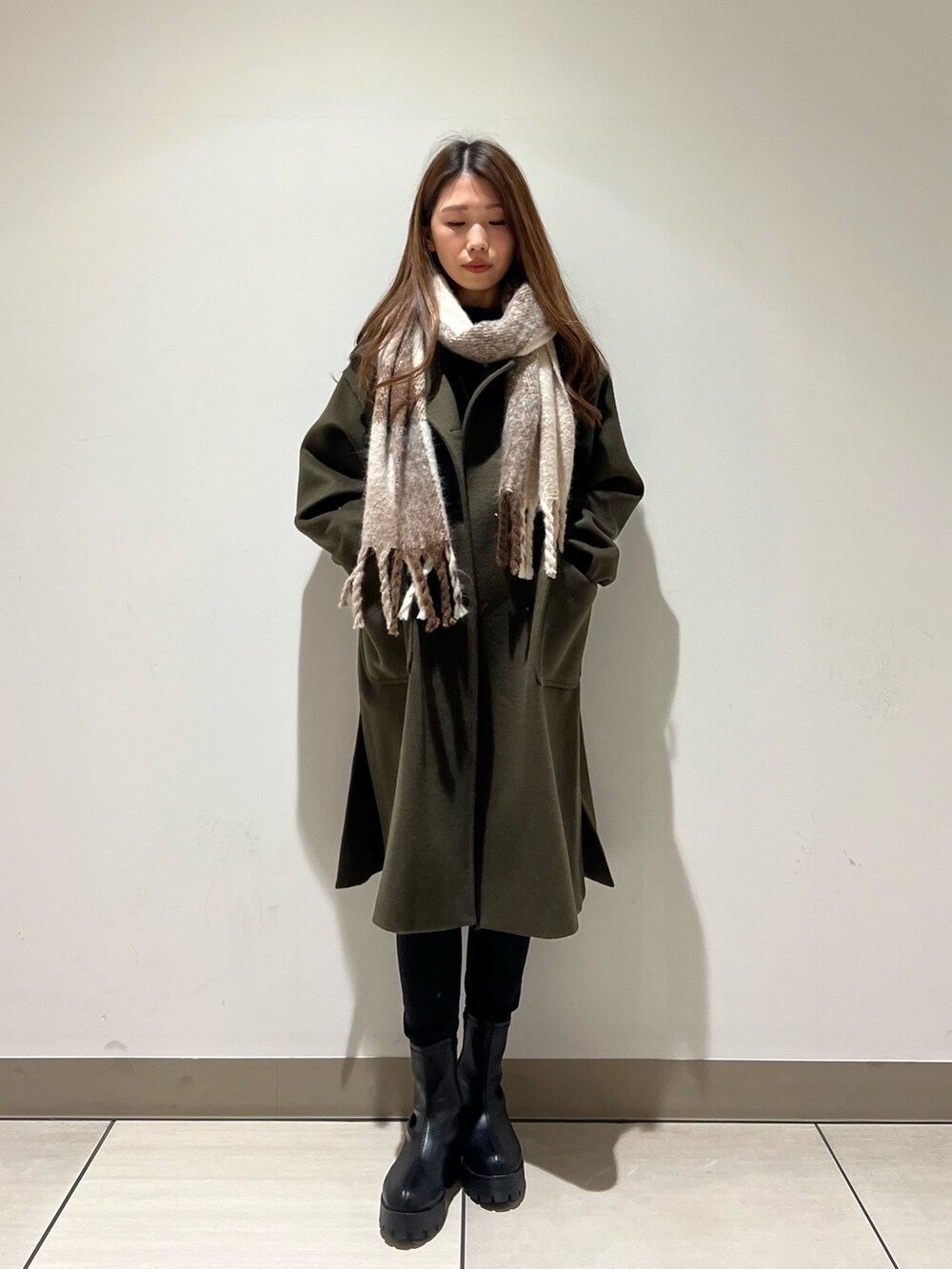 グリーン系のその他アウター、ブルー系のTシャツ/カットソー、ベージュ系のストール/ショールを着用したレディースの冬コーディネートの3枚目の写真