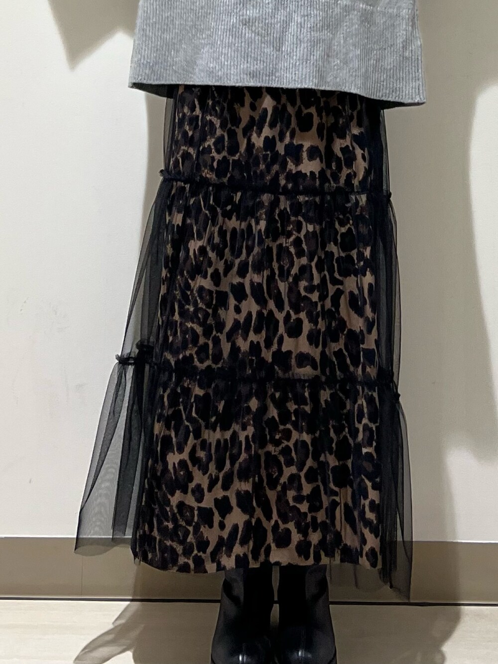 ベージュ系のスカート、グレー系のニット/セーター、ブラック系のトートバッグを着用したレディースの冬コーディネートの3枚目の写真