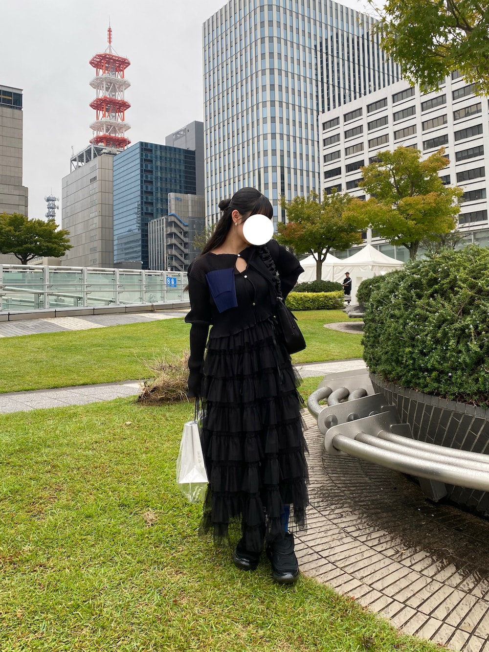 ブラック系のカーディガン/ボレロ、ベージュ系のスカート、ブラック系のスニーカーを着用したレディースの秋コーディネートの3枚目の写真