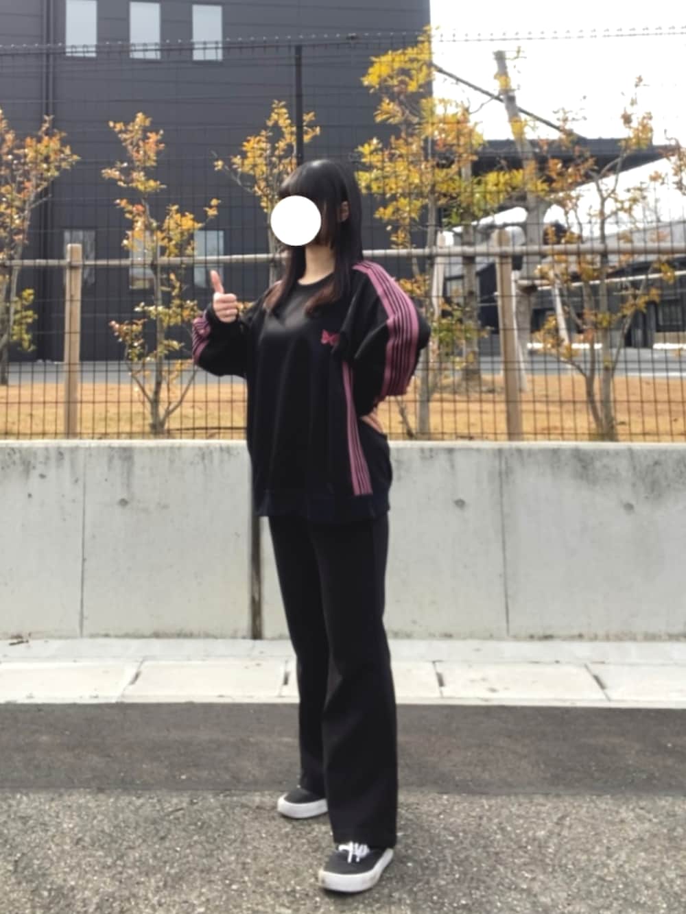 ブラック系のスラックス、ブラック系のトップス、ブラック系のスニーカーを着用したレディースの冬コーディネートの2枚目の写真