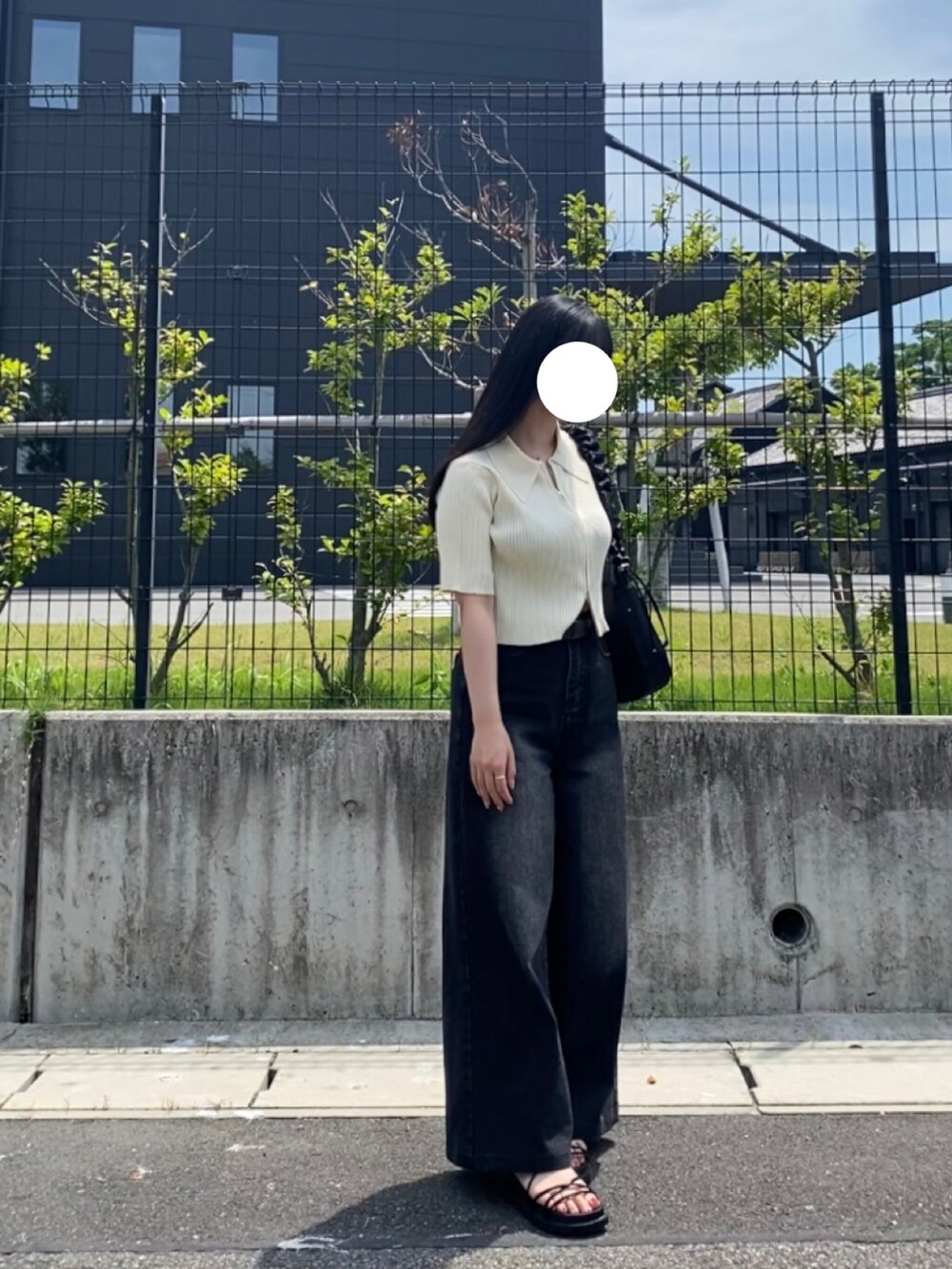 ホワイト系のニット/セーター、ブラック系のデニムパンツ、ブラック系のバッグを着用したレディースの夏コーディネートの2枚目の写真