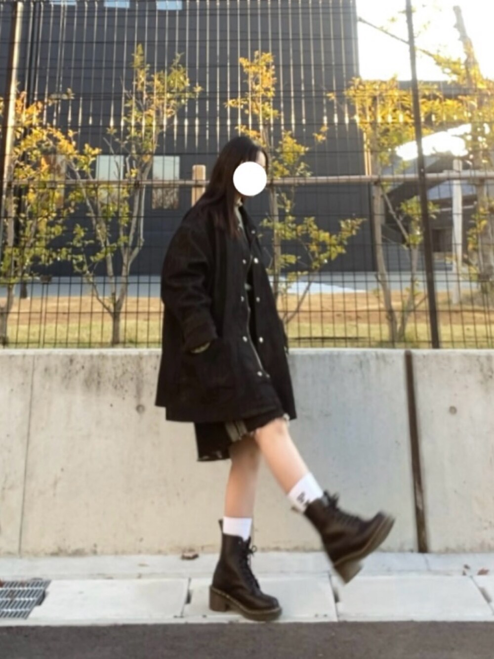 ブラック系のデニムジャケット、ブラック系のデニムスカート、グリーン系のニット/セーターを着用したレディースの冬コーディネートの2枚目の写真