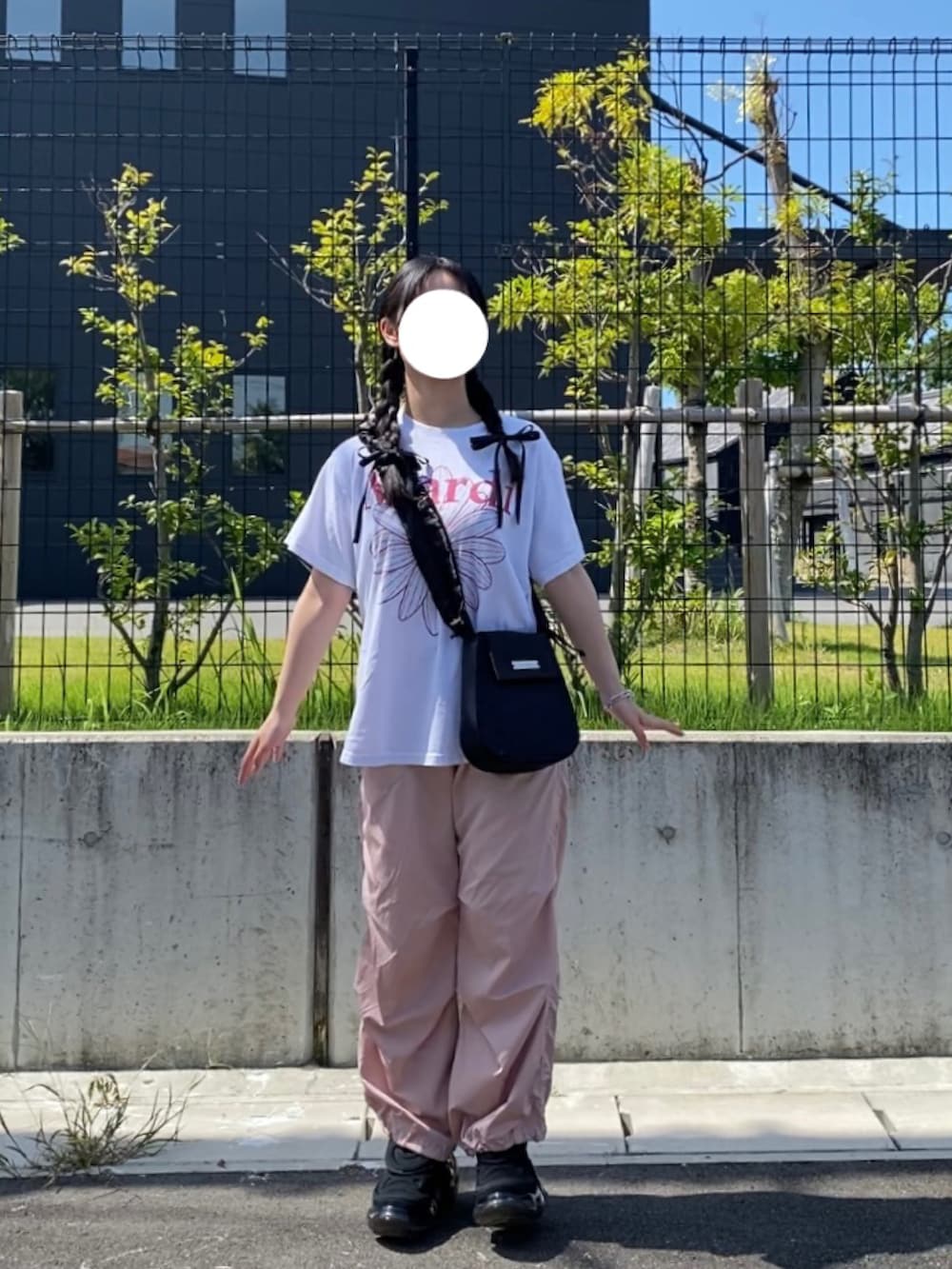 ホワイト系のTシャツ/カットソー、ブラック系のスニーカー、ブラック系のバッグを着用したレディースの夏コーディネートの2枚目の写真