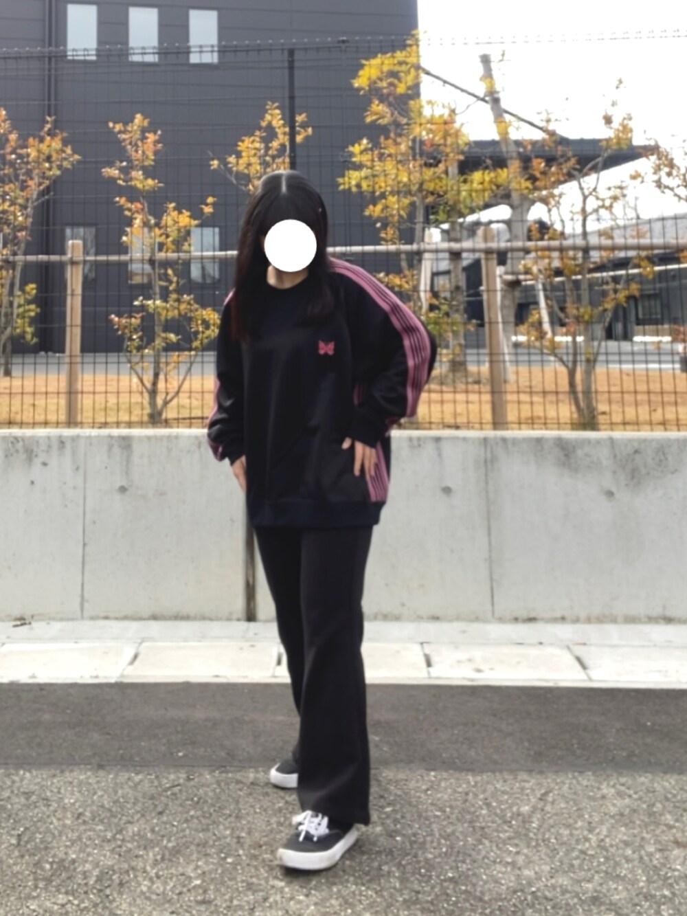 ブラック系のスラックス、ブラック系のトップス、ブラック系のスニーカーを着用したレディースの冬コーディネートの3枚目の写真