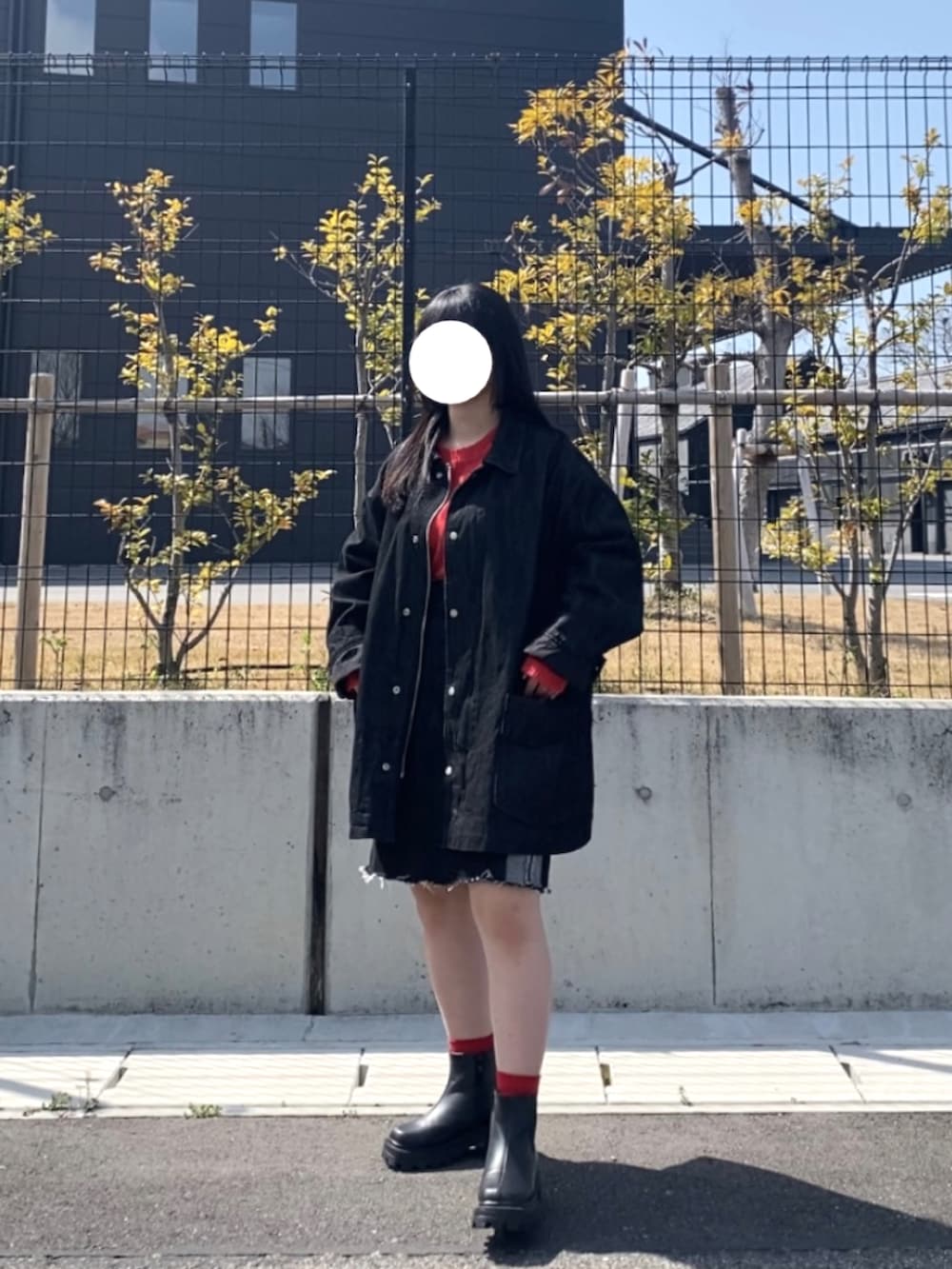 ブラック系のデニムジャケット、ブラック系のデニムスカート、ブラック系のブーツを着用したレディースの春コーディネートの3枚目の写真