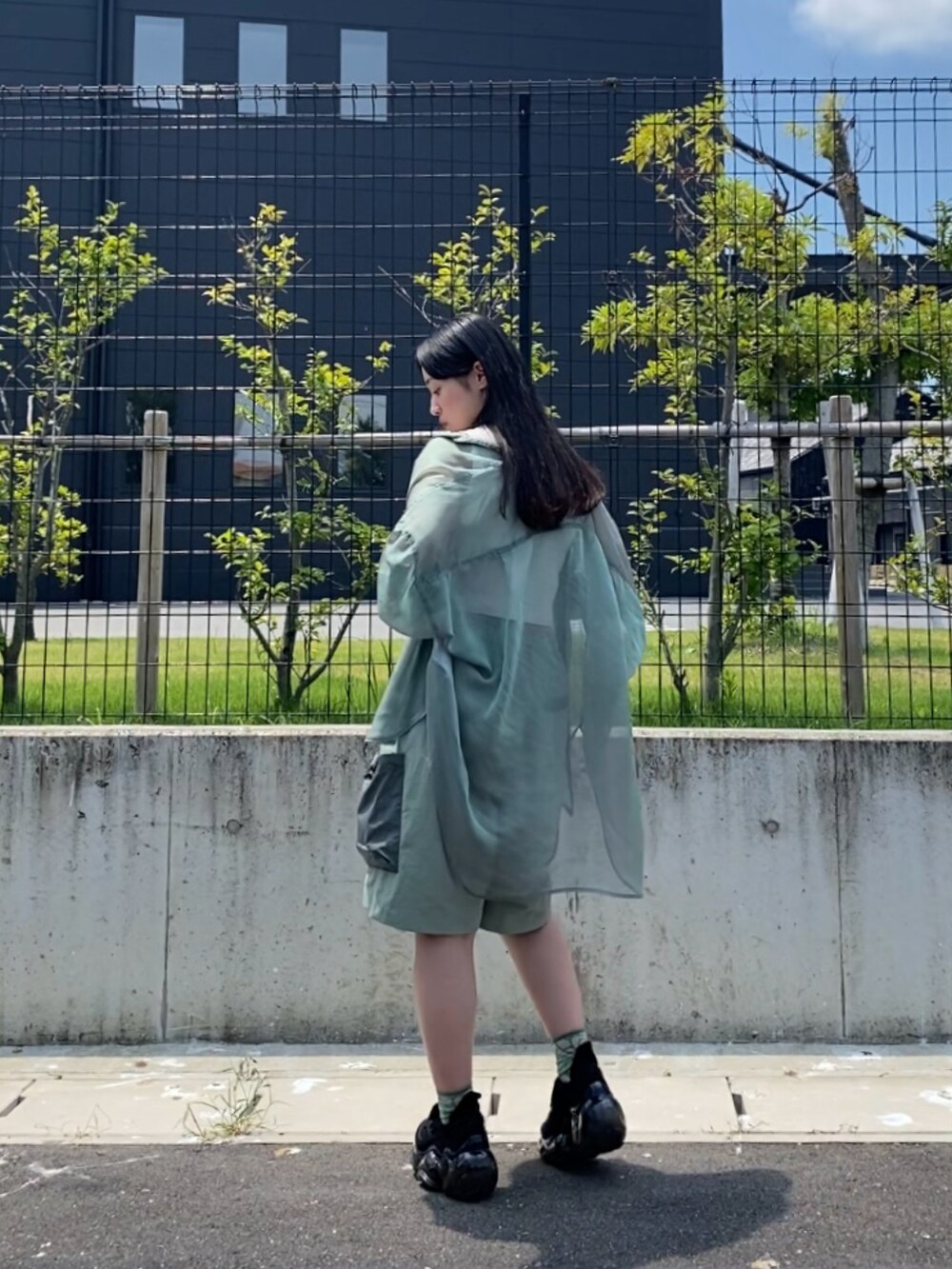 グリーン系のシャツ/ブラウス、ホワイト系のタンクトップ、グリーン系のパンツを着用したレディースの夏コーディネートの3枚目の写真