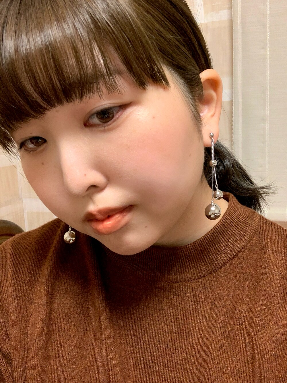 ブラウン系のニット/セーター、ブラウン系のブーツ、ブラウン系のスカートを着用したレディースの秋コーディネートの2枚目の写真