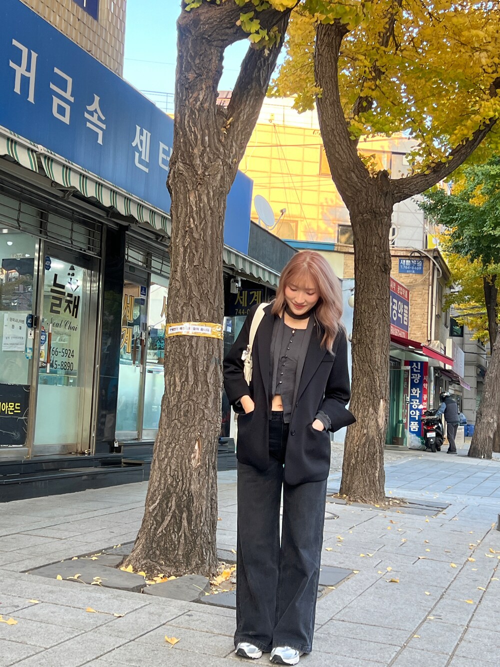 ブラック系のデニムパンツ、シルバー系のスニーカーを着用したレディースの秋コーディネートの3枚目の写真