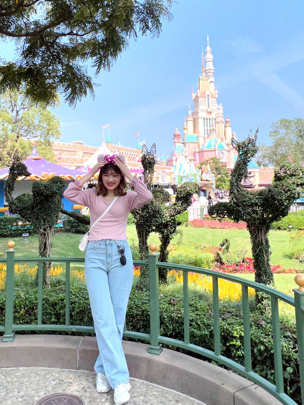 ブルー系のデニムパンツ、ベージュ系のスニーカーを着用したレディースの夏コーディネートの2枚目の写真