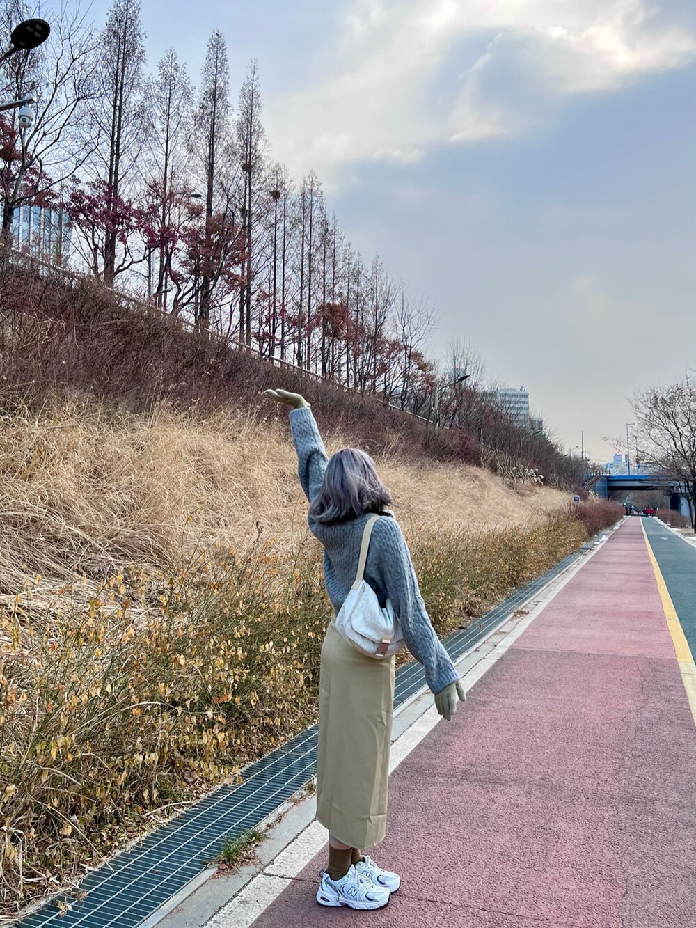 ホワイト系のスニーカー、ホワイト系のショルダーバッグを着用したレディースの冬コーディネートの3枚目の写真