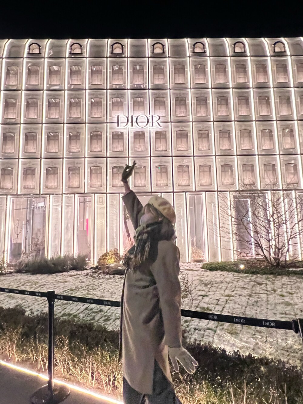 グレー系のノーカラーコートを着用したレディースの冬コーディネートの2枚目の写真