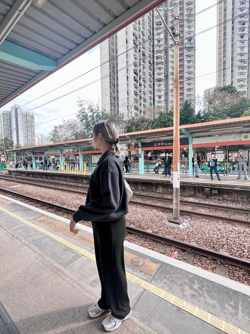 ブルー系のパーカー、ホワイト系のスニーカー、ホワイト系のショルダーバッグを着用したレディースの冬コーディネートの2枚目の写真