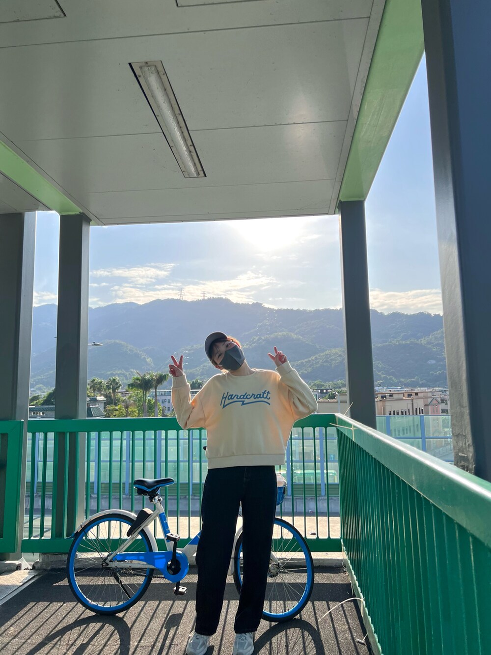 グリーン系のショルダーバッグを着用したレディースの夏コーディネートの3枚目の写真