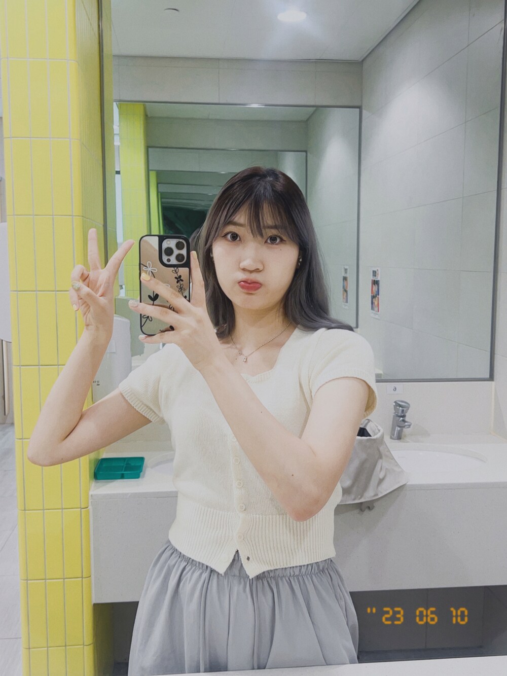 ベージュ系のニット/セーター、ホワイト系のスニーカーを着用したレディースの夏コーディネートの2枚目の写真