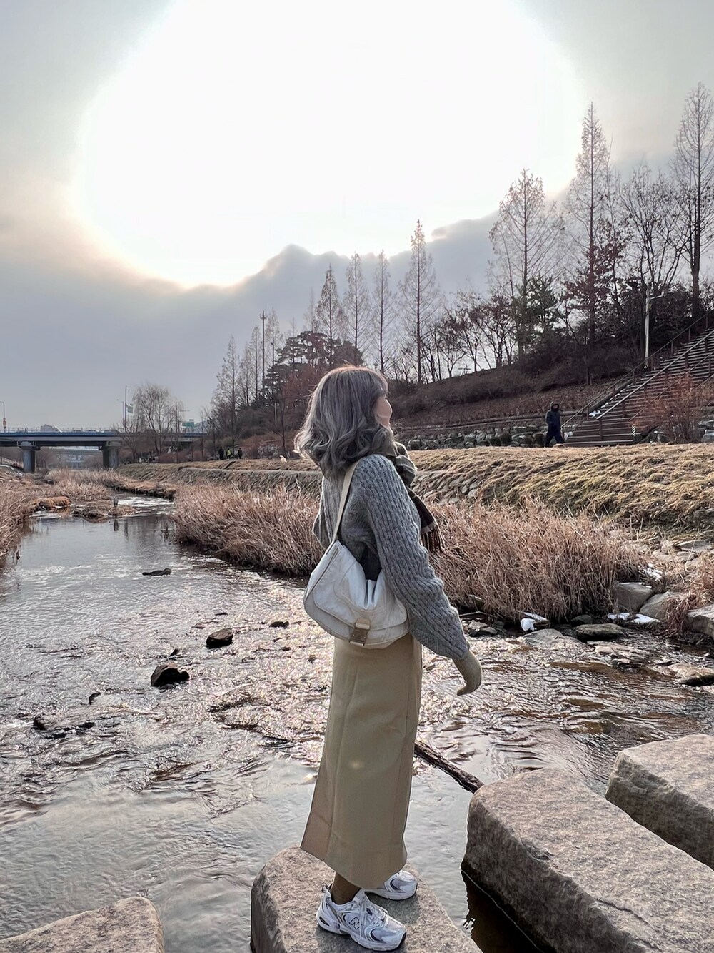 ホワイト系のスニーカー、ホワイト系のショルダーバッグを着用したレディースの冬コーディネートの2枚目の写真