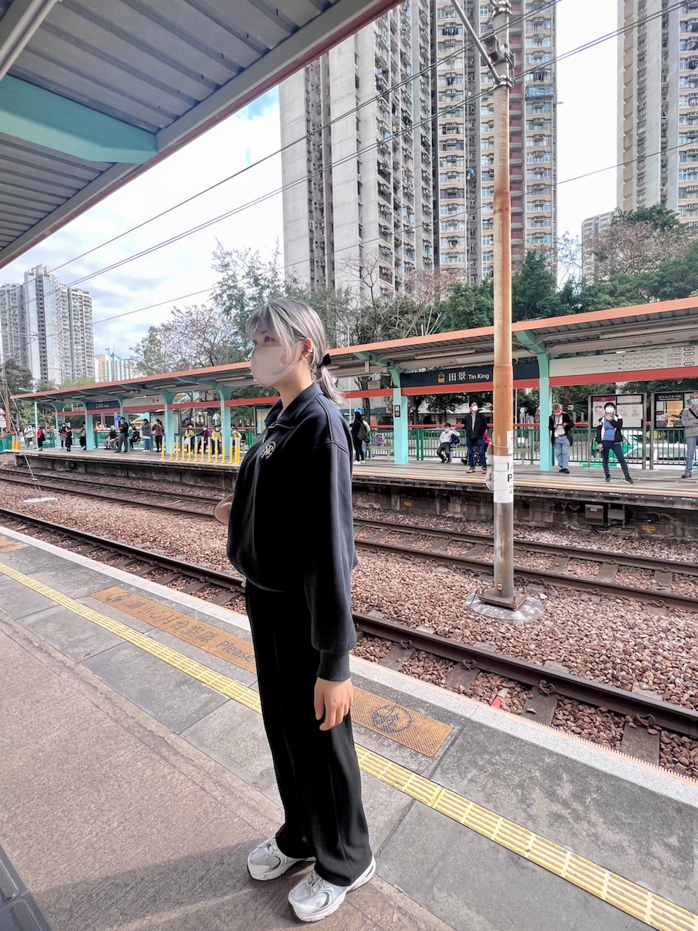 ブルー系のパーカー、ホワイト系のスニーカー、ホワイト系のショルダーバッグを着用したレディースの冬コーディネートの3枚目の写真