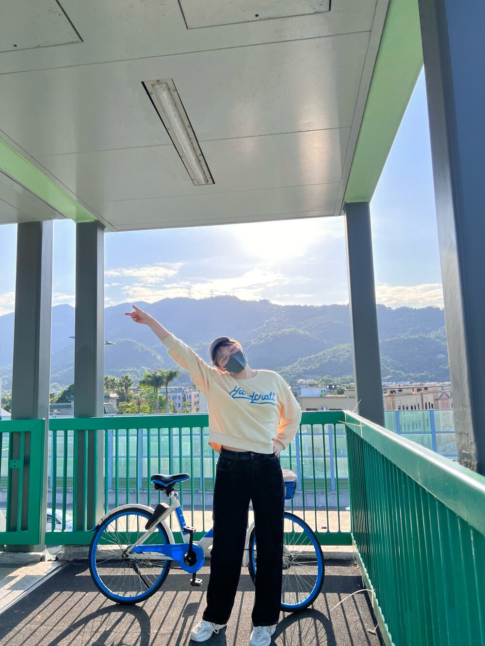 グリーン系のショルダーバッグを着用したレディースの夏コーディネートの2枚目の写真