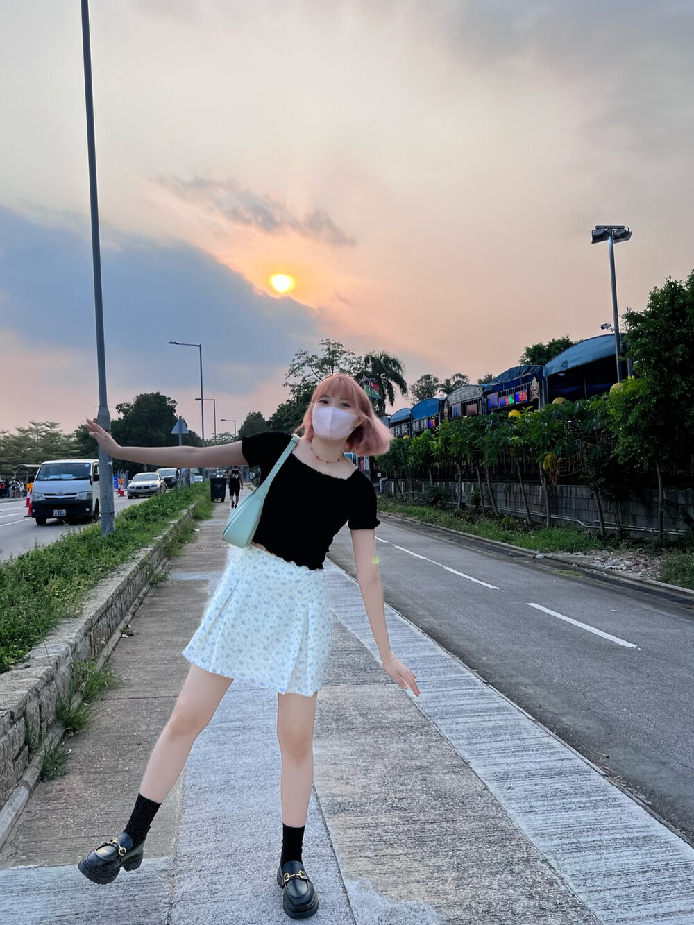 グリーン系のショルダーバッグ、ブラック系のトップスを着用したレディースの秋コーディネートの2枚目の写真