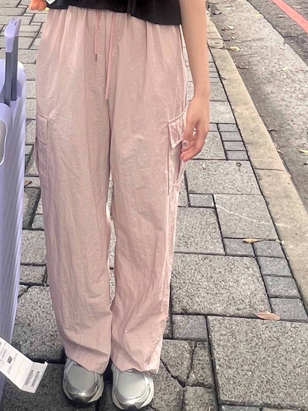 ピンク系のチノパンツ、シルバー系のスニーカー、ブラック系のキャミソールを着用したレディースの夏コーディネートの3枚目の写真