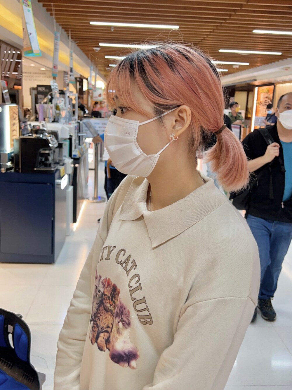 グレー系のスニーカー、ベージュ系のトップス、ホワイト系のショルダーバッグを着用したレディースの秋コーディネートの4枚目の写真