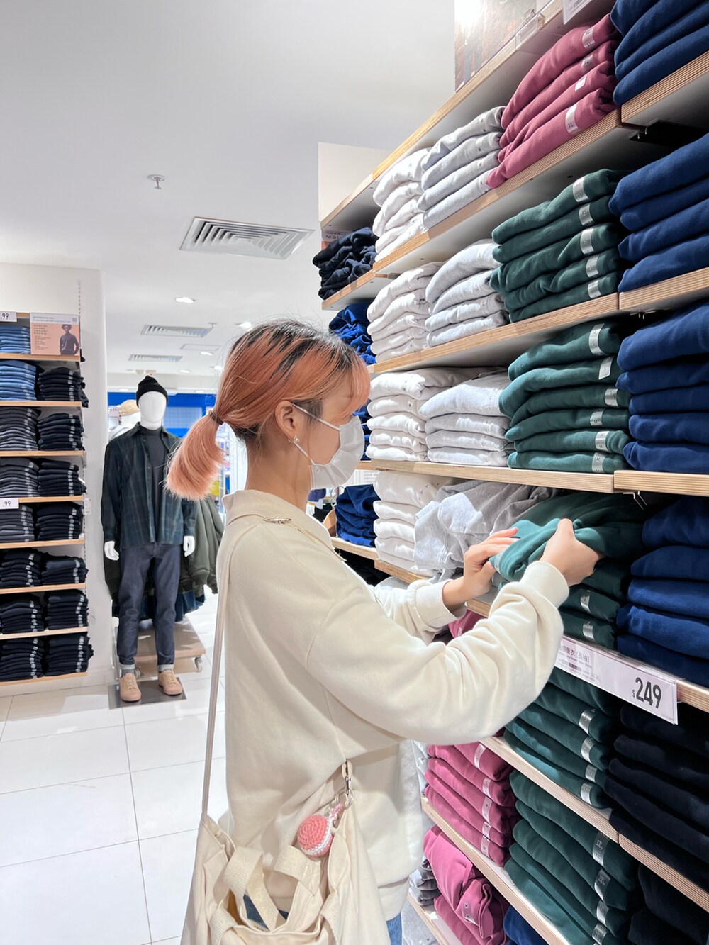 グレー系のスニーカー、ベージュ系のトップス、ホワイト系のショルダーバッグを着用したレディースの秋コーディネートの3枚目の写真