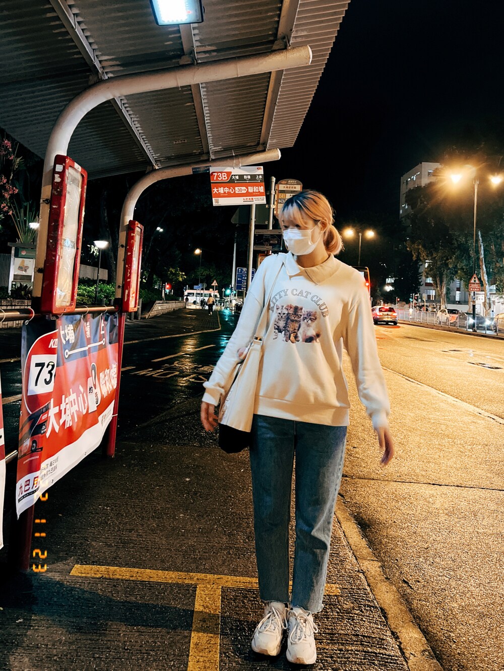 グレー系のスニーカー、ベージュ系のトップス、ホワイト系のショルダーバッグを着用したレディースの秋コーディネートの2枚目の写真