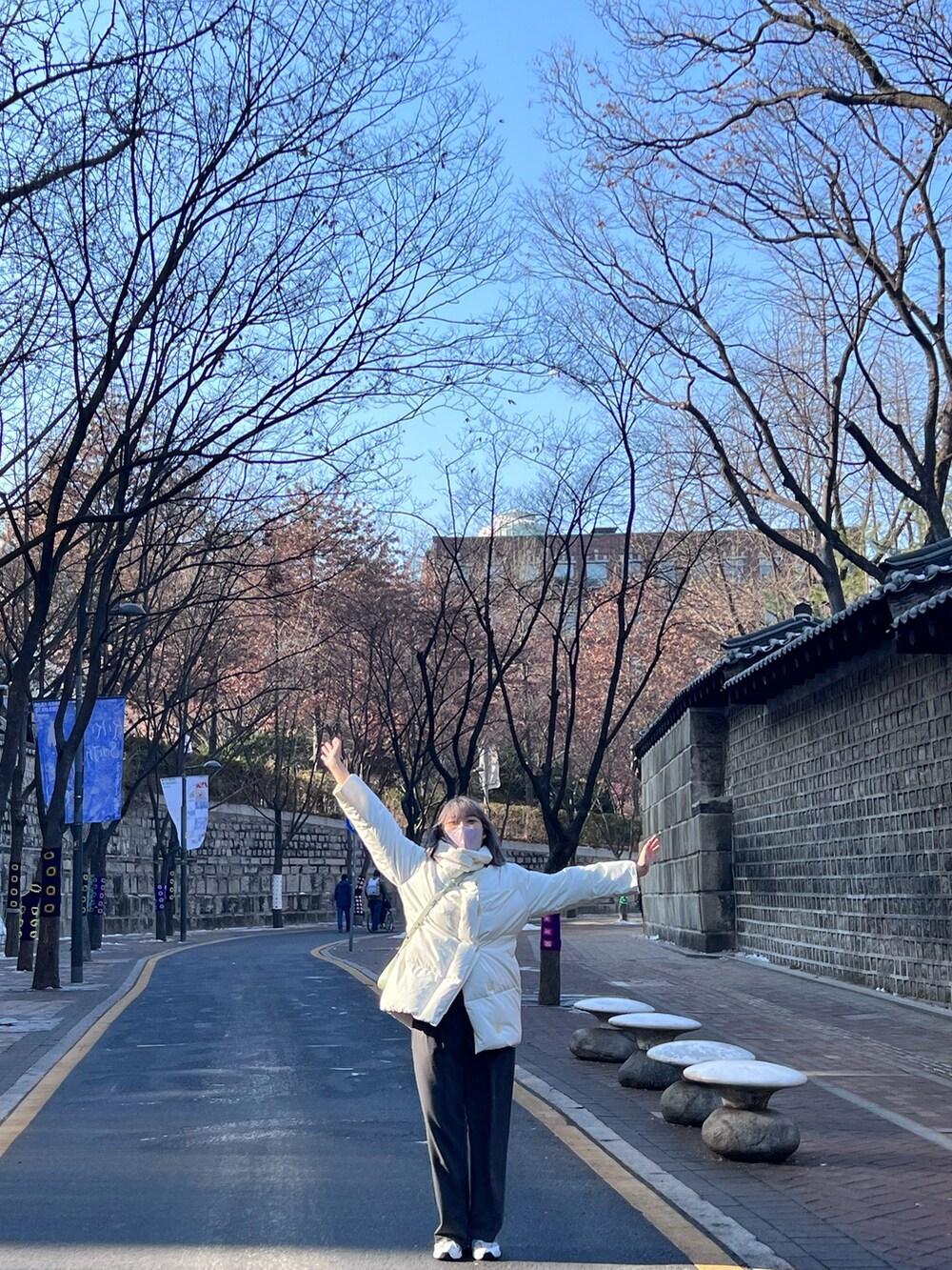 ホワイト系のスニーカー、グリーン系のショルダーバッグを着用したレディースの冬コーディネートの3枚目の写真