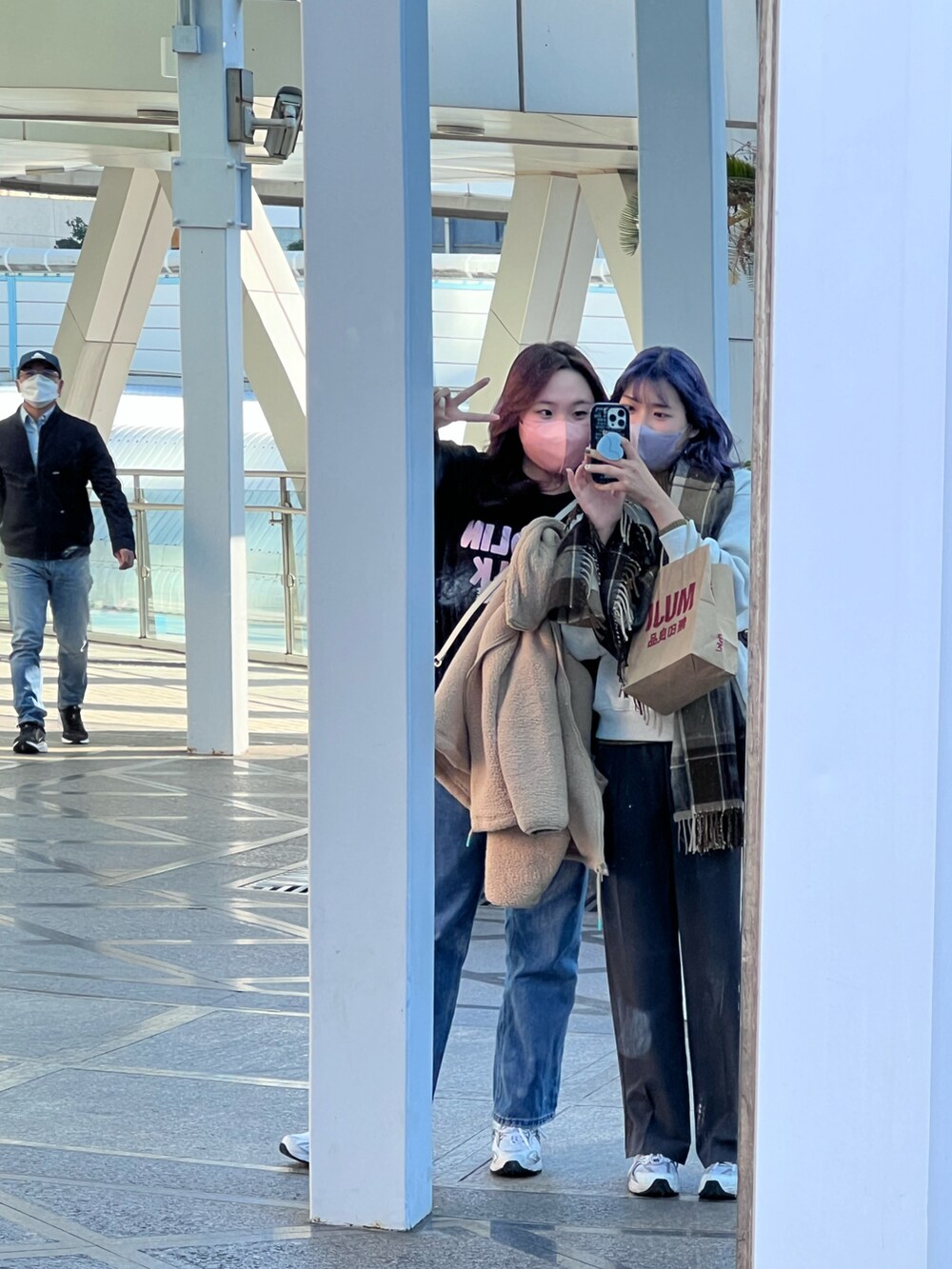 ブラック系のショルダーバッグ、ホワイト系のスニーカーを着用したレディースの冬コーディネートの4枚目の写真