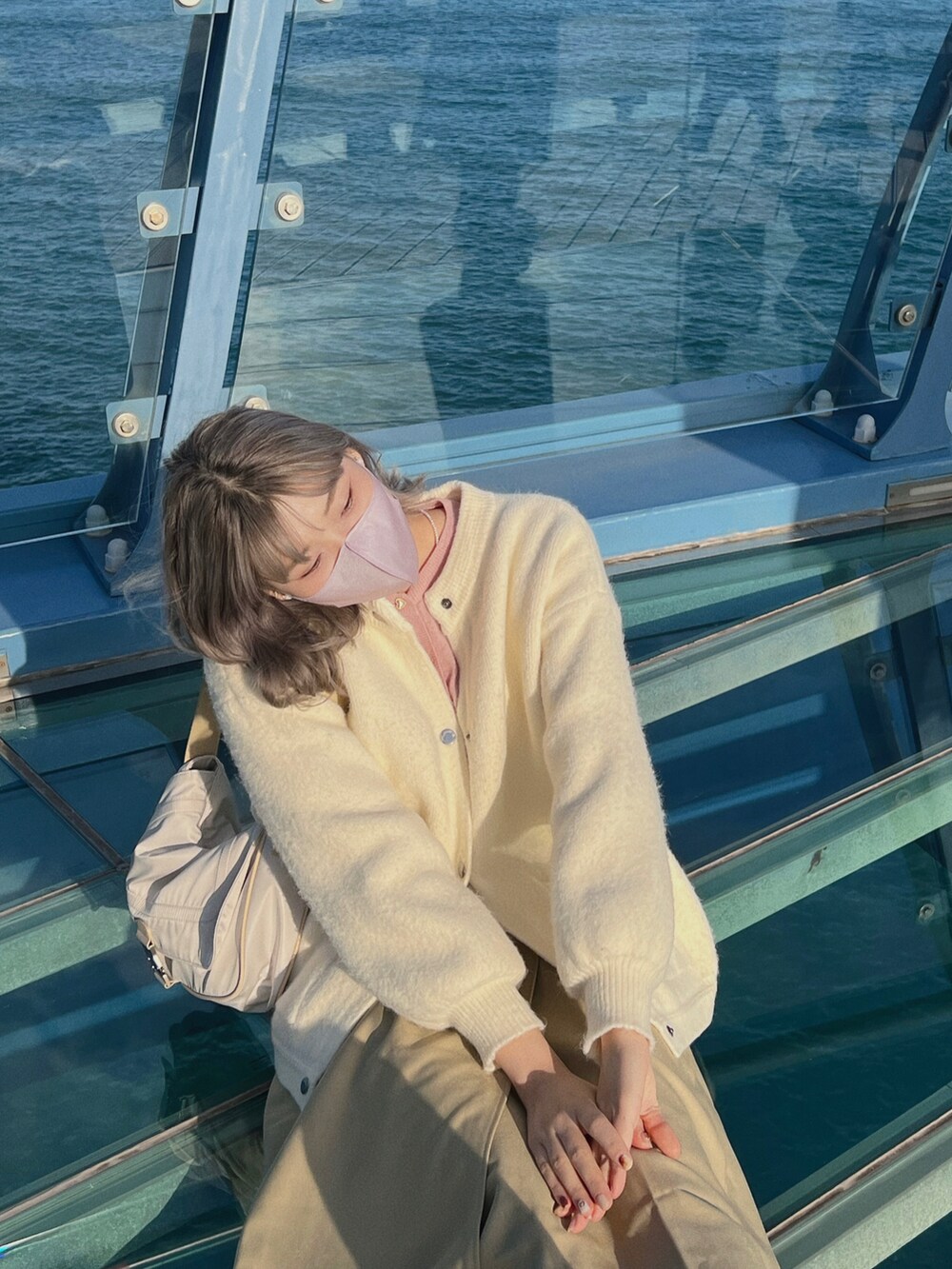 ホワイト系のショルダーバッグを着用したレディースの冬コーディネートの2枚目の写真