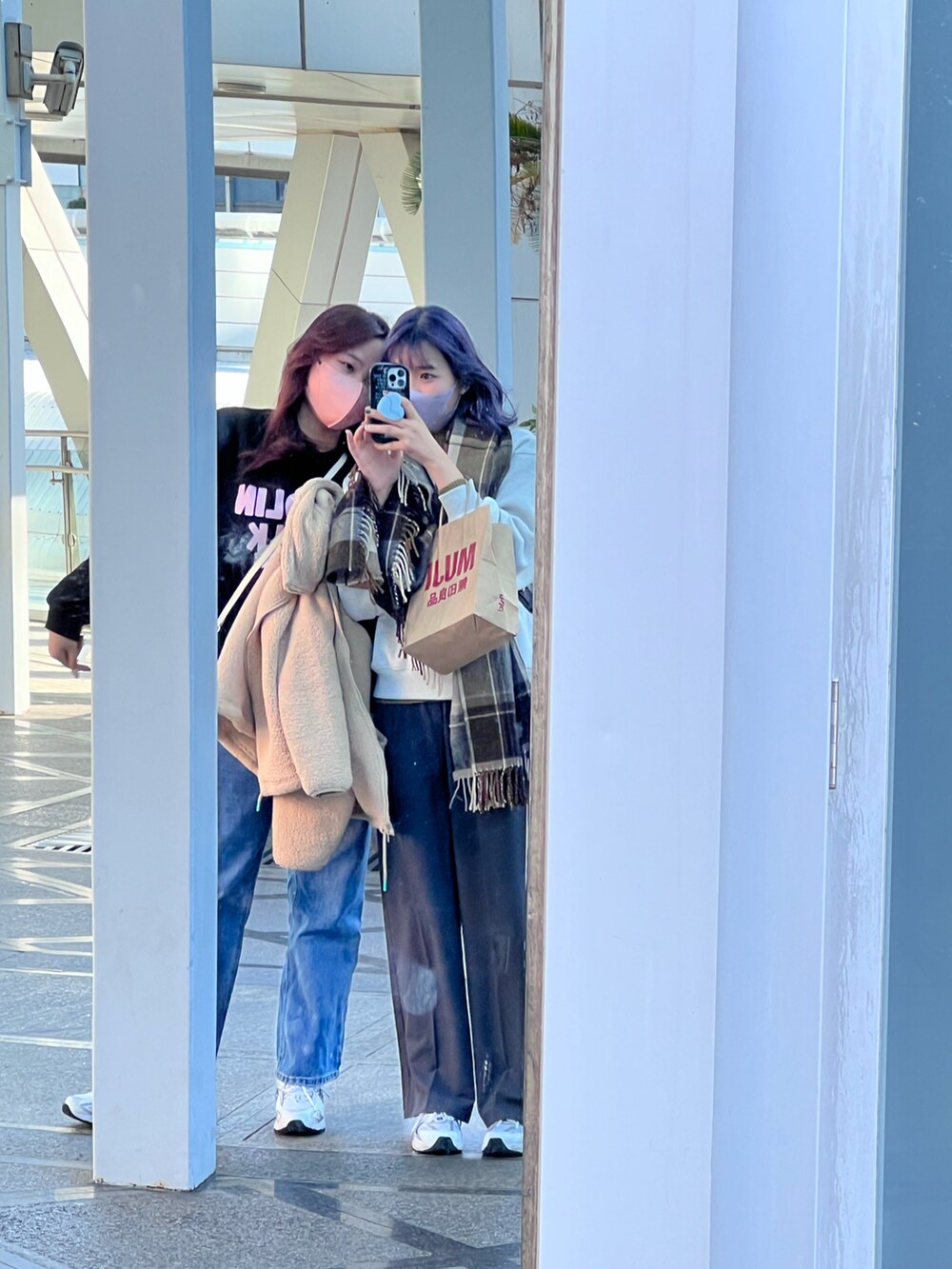 ブラック系のショルダーバッグ、ホワイト系のスニーカーを着用したレディースの冬コーディネートの3枚目の写真