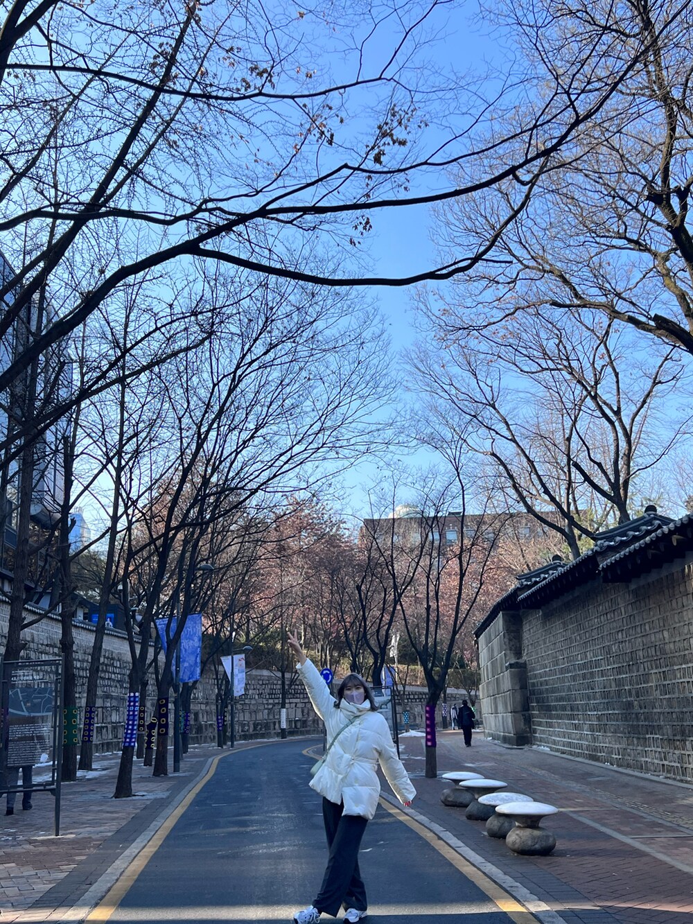 ホワイト系のスニーカー、グリーン系のショルダーバッグを着用したレディースの冬コーディネートの2枚目の写真