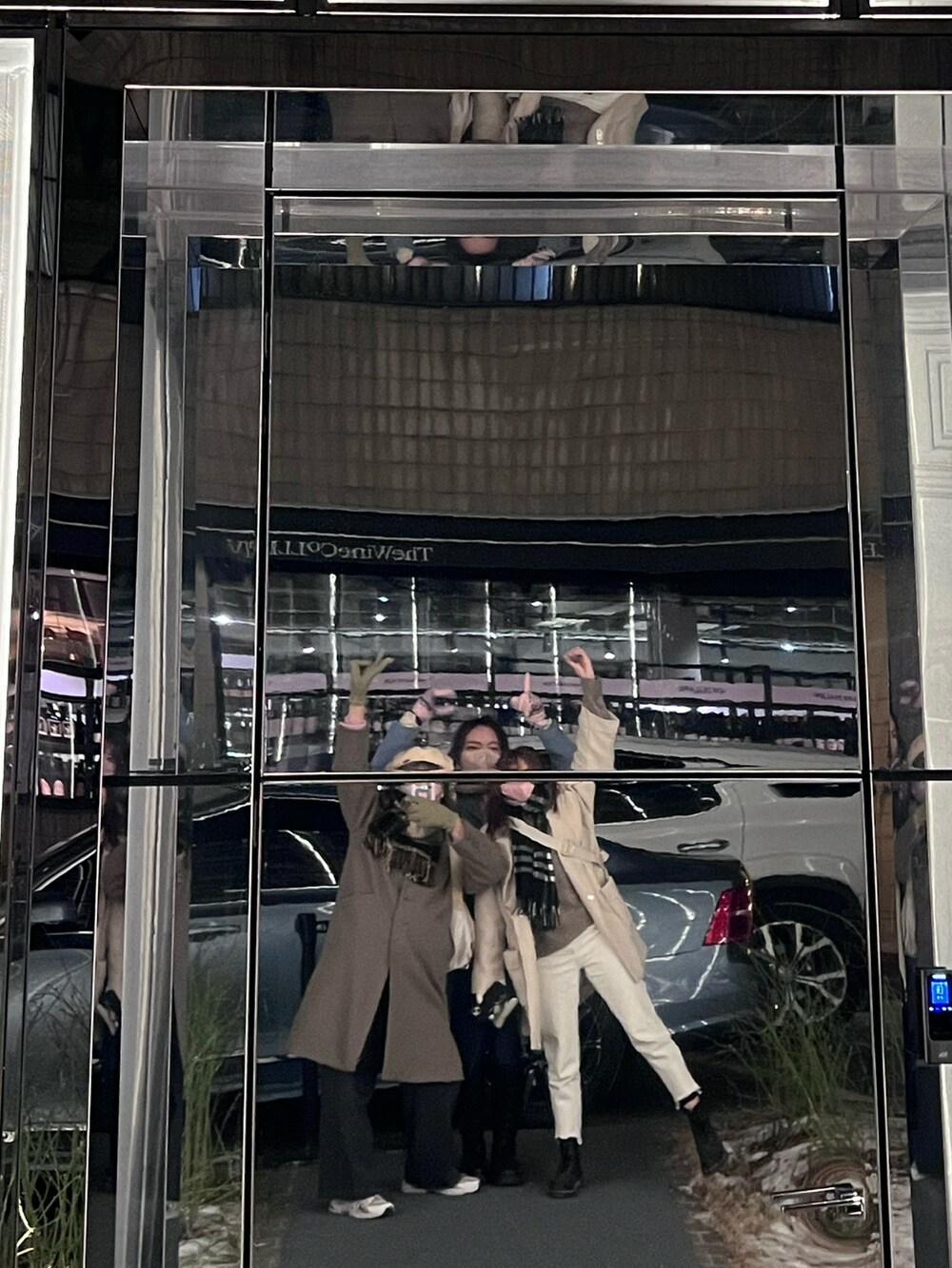 グレー系のノーカラーコートを着用したレディースの冬コーディネートの3枚目の写真