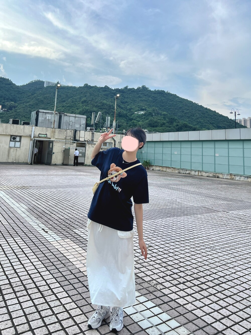 ホワイト系のスニーカー、ベージュ系のスカートを着用したレディースの夏コーディネートの2枚目の写真