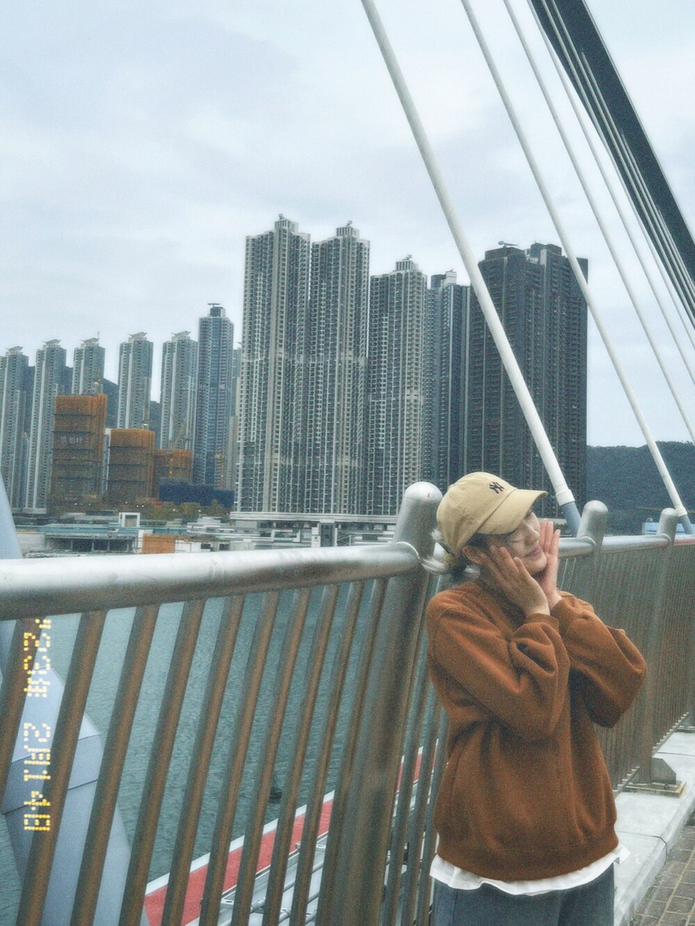 ホワイト系のスニーカー、グリーン系のショルダーバッグ、ベージュ系のキャップを着用したレディースの冬コーディネートの3枚目の写真