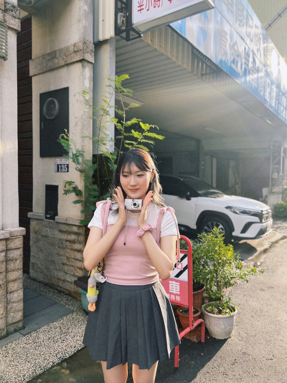 シルバー系のスニーカー、ピンク系のトップスを着用したレディースの夏コーディネートの3枚目の写真