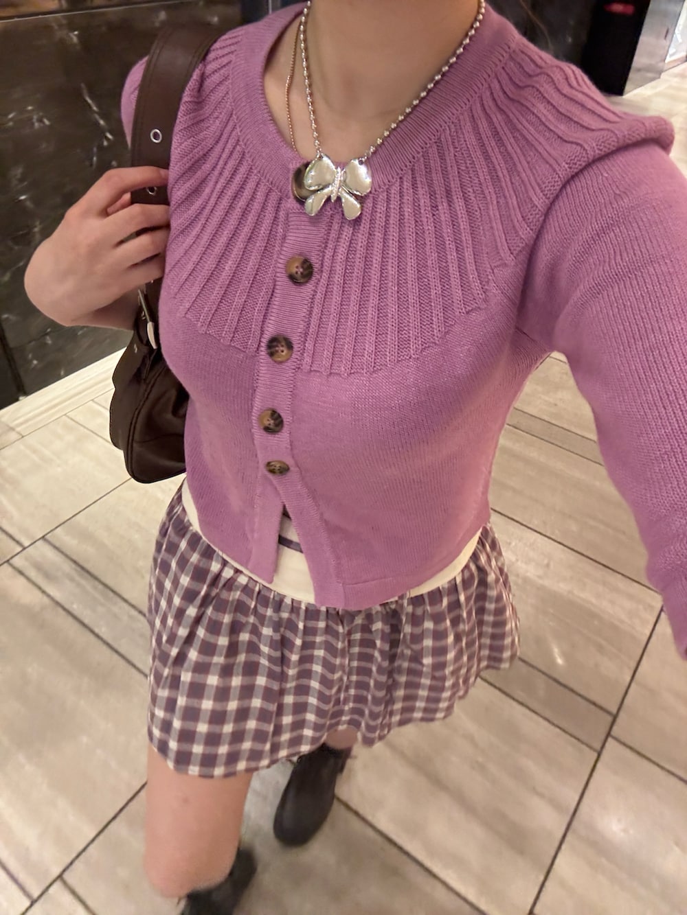 ピンク系のカーディガン/ボレロ、グレー系のスカート、ブラック系のブーツを着用したレディースの夏コーディネートの4枚目の写真