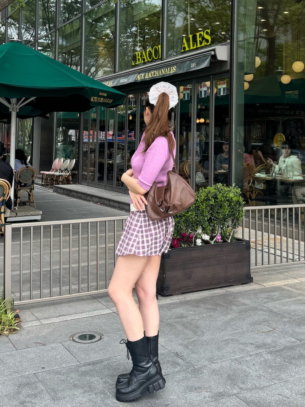 ピンク系のカーディガン/ボレロ、グレー系のスカート、ブラック系のブーツを着用したレディースの夏コーディネートの2枚目の写真