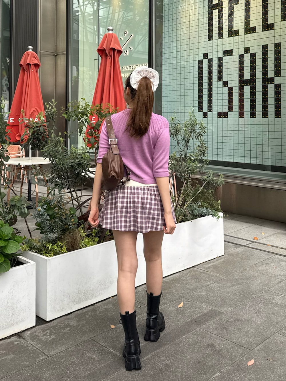 ピンク系のカーディガン/ボレロ、グレー系のスカート、ブラック系のブーツを着用したレディースの夏コーディネートの3枚目の写真