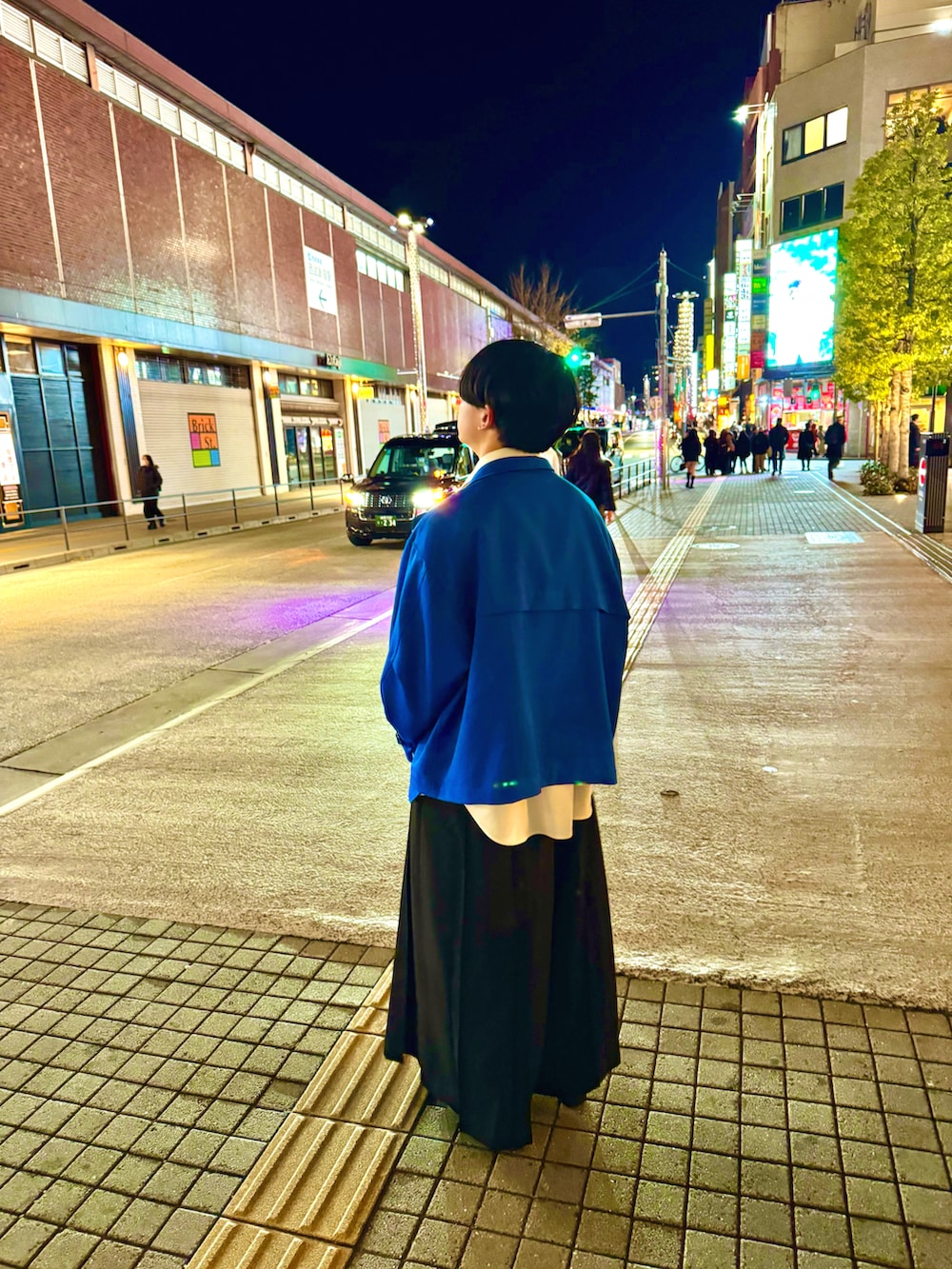 ブラック系のスラックス、ブルー系のブルゾン、ホワイト系のシャツ/ブラウスを着用したメンズの夏コーディネートの2枚目の写真