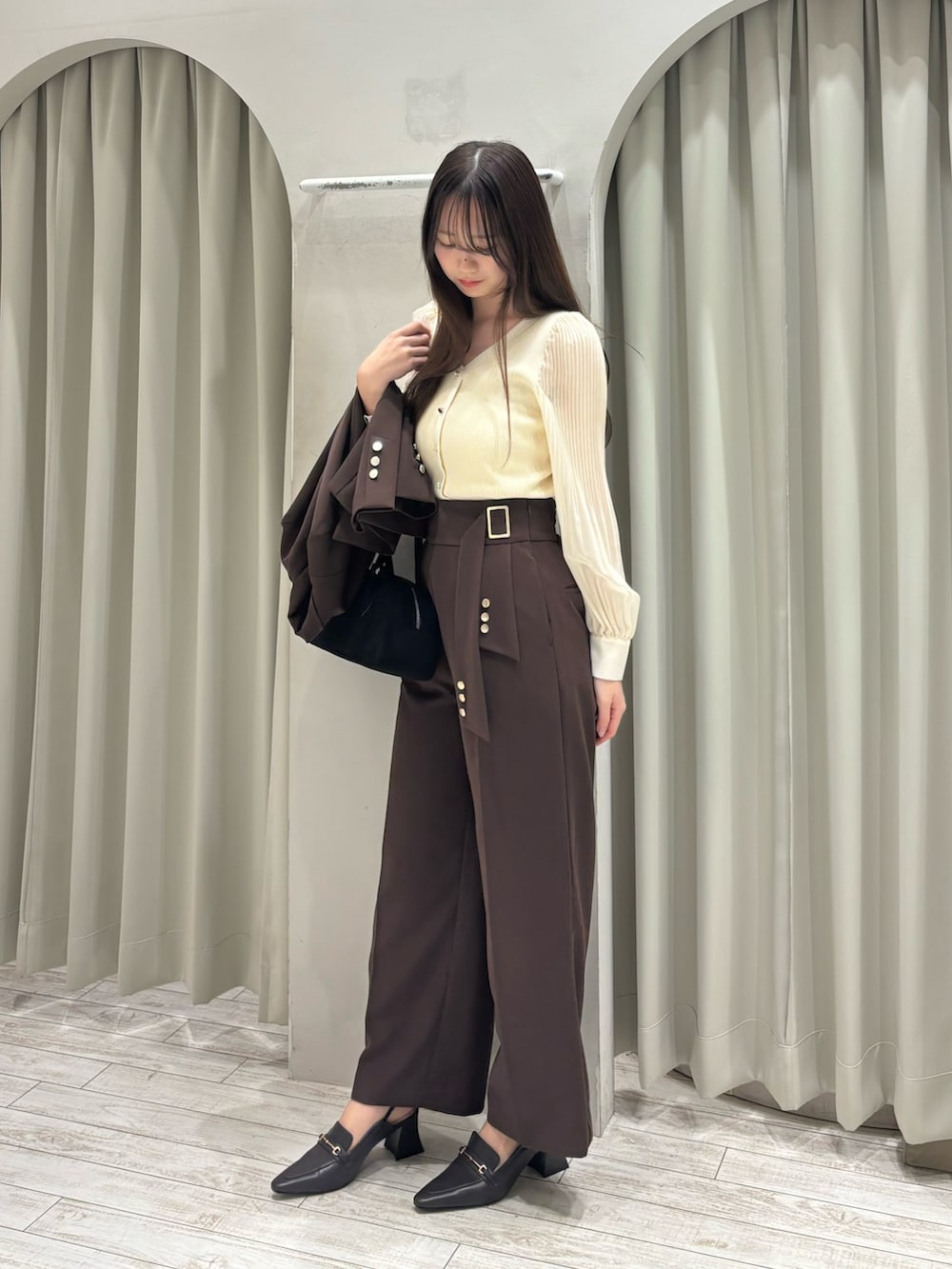 ブラウン系のテーラードジャケット、ホワイト系のニット/セーター、ブラウン系のその他パンツを着用したレディースの春コーディネートの7枚目の写真