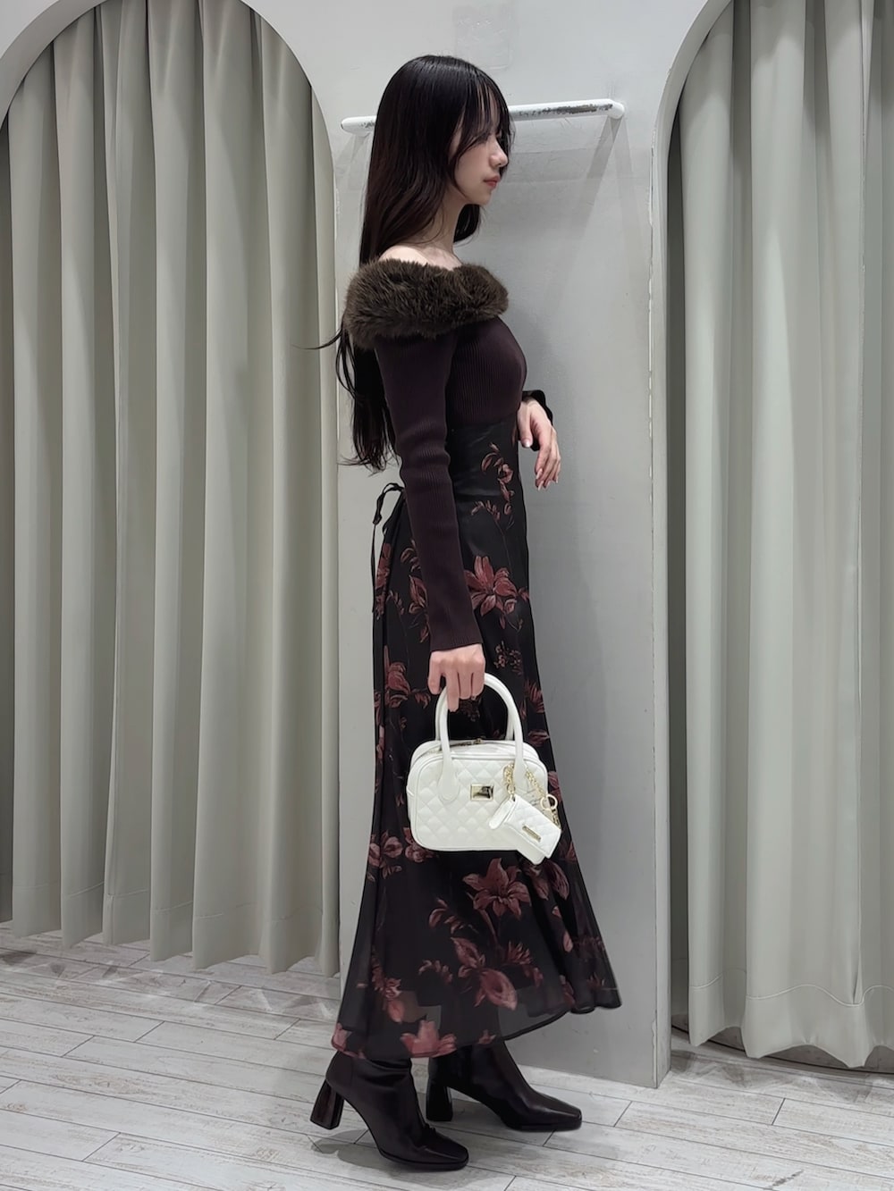 ブラウン系のワンピース、ホワイト系のハンドバッグ、ブラウン系のブーツを着用したレディースの冬コーディネートの4枚目の写真